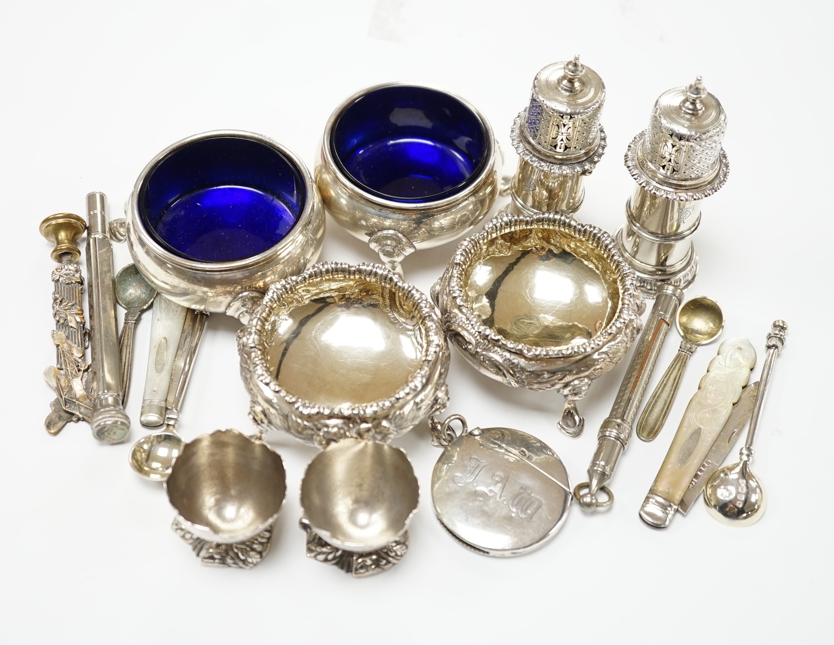 A pair of George II silver bun salts, London, 1735, diameter 60mm, a later pair of Victorian silver salts, a pair of Edwardian silver pepperettes by William Comyns and sundry other items including a circular silver vesta